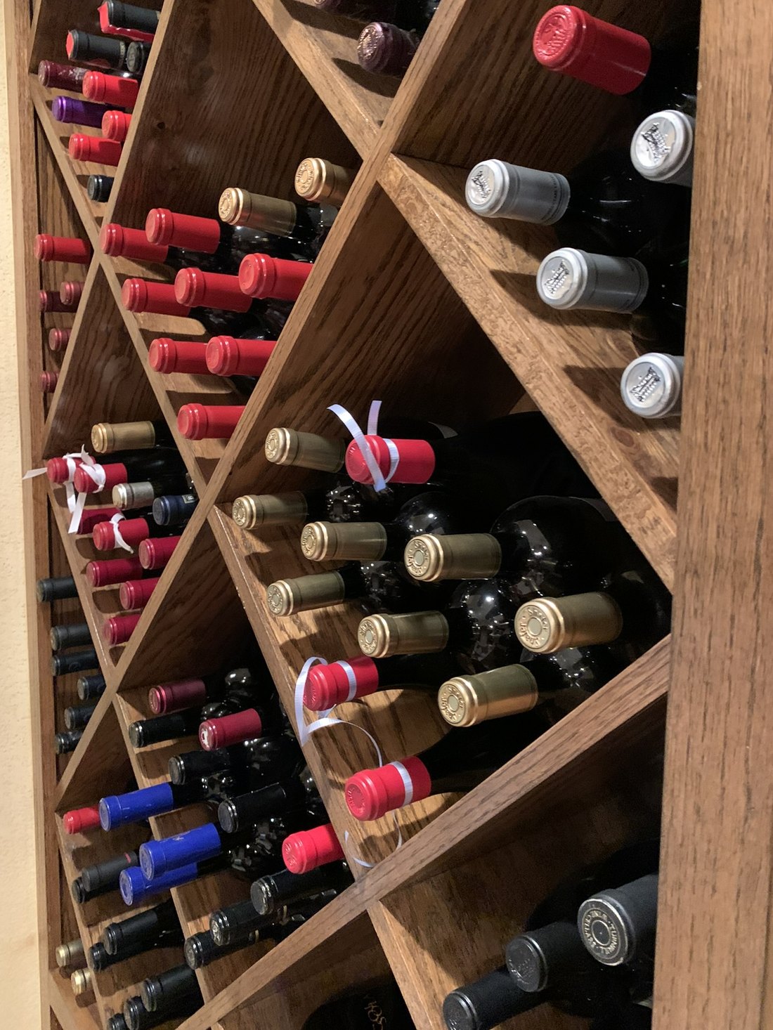 Wine bottles being placed into diamond bin racking in a private cellar