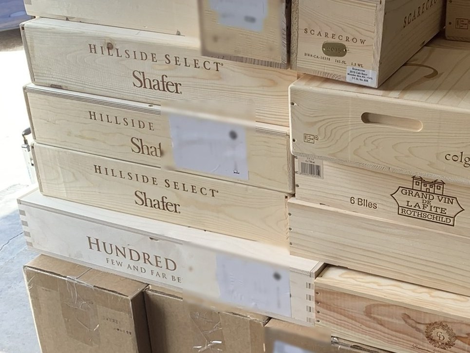 Original wooden cases stacked on a consignment pallet at the DFW facility